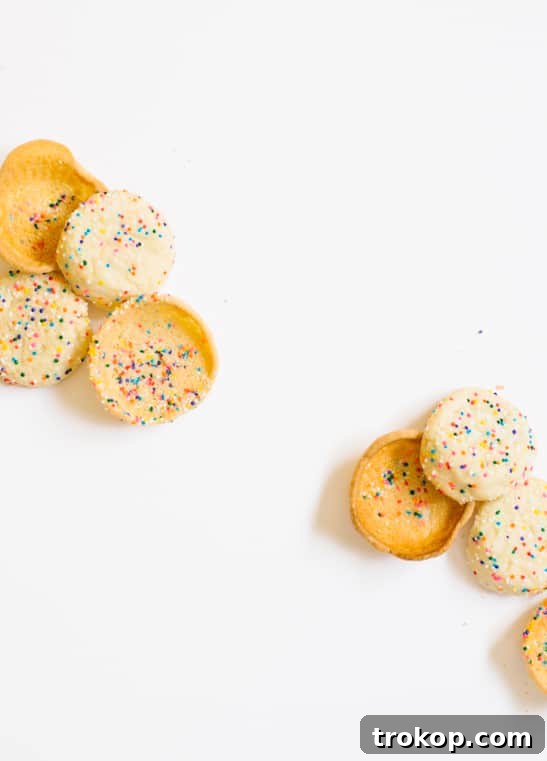 Freshly baked cookie cups cooling on an inverted muffin tin, maintaining their perfect cup shape.