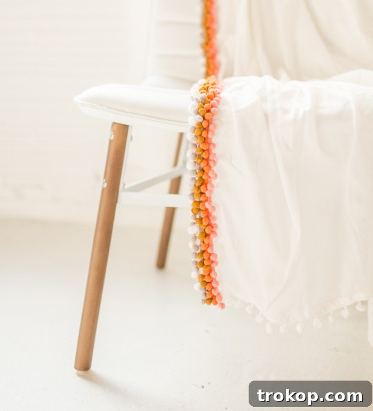 Summer Style Spark: DIY Pom Pom Throw Decor Ideas 3 Colorful Pom Pom Throw Blanket on a Sofa