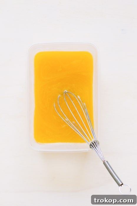 Pouring hot mango nectar into cold with bloomed gelatin