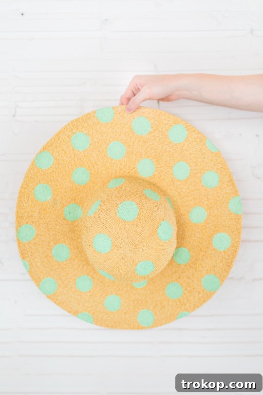 Stylish DIY Polka Dot Floppy Hat 6 Woman applying polka dots to a floppy hat using a foam pouncer in a step-by-step DIY process, demonstrating the creation of a unique pattern.
