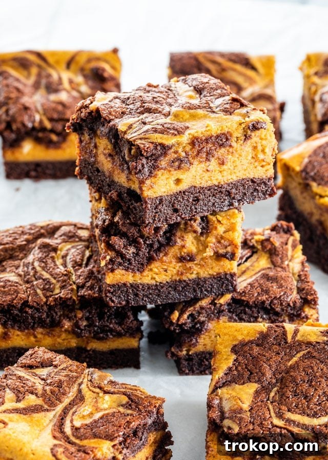 Decadent pumpkin cheesecake brownies combining a fudgy brownie base with a creamy pumpkin cheesecake layer, perfect for fall.