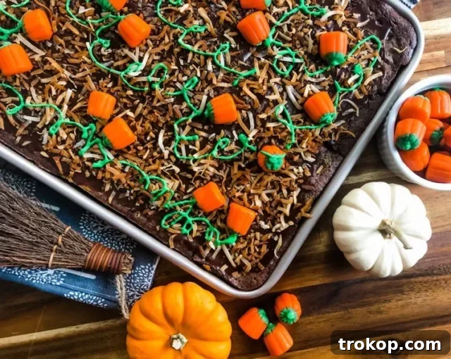Pumpkin patch brownies adorned with candied pumpkins, toasted coconut, and green frosting, a picturesque Thanksgiving dessert.