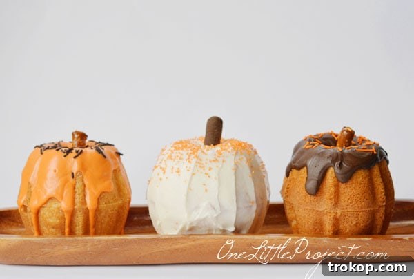Charming mini pumpkin bundt cakes, moist spiced pumpkin cake with glaze and pretzel rod 'stems', perfect for individual servings.