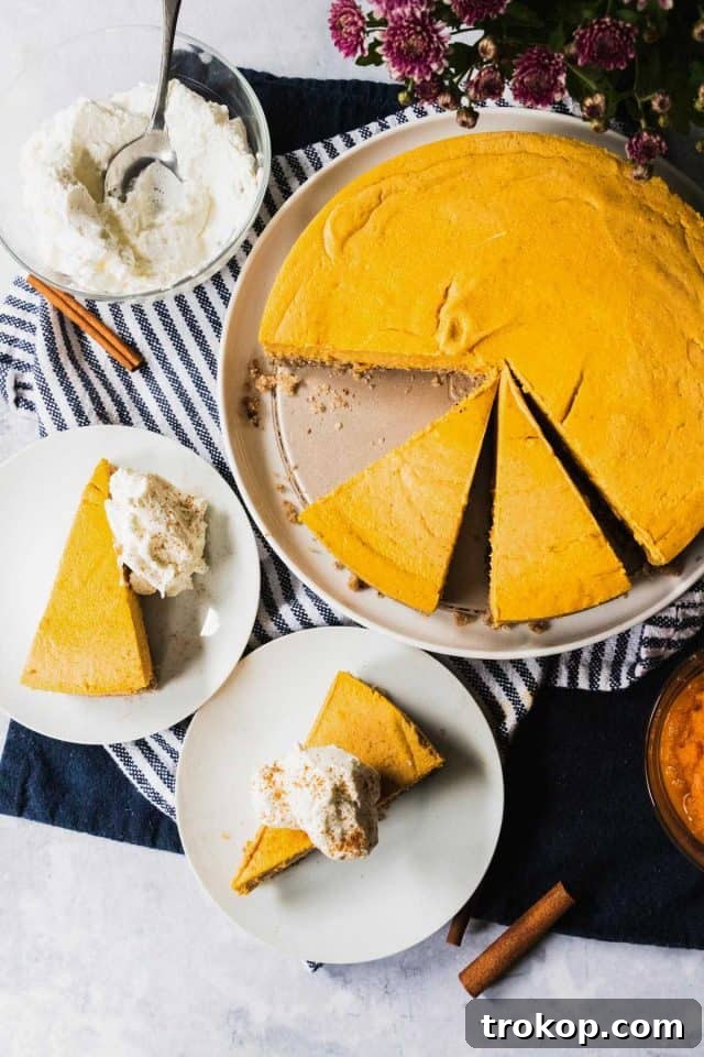 Guilt-free keto pumpkin cheesecake, a low-carb indulgence for Thanksgiving dessert tables, with or without whipped cream.