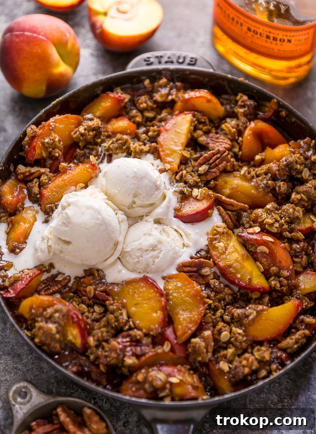 Bourbon Pecan Peach Crisp: juicy peaches, a hint of bourbon, and a crunchy brown sugar oat topping with pecans, baked in a skillet.