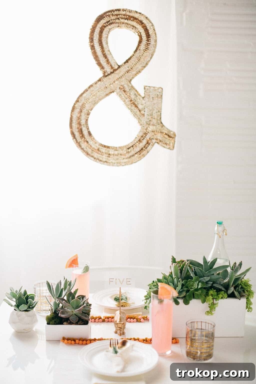 Vibrant DIY pom pom placemats for summer entertaining with white, gold, and colorful accents
