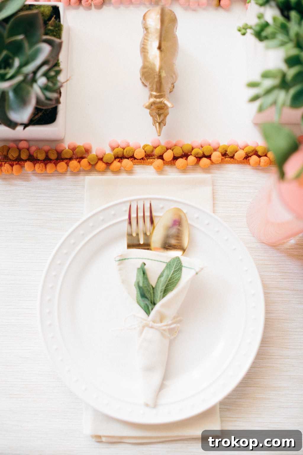 Close-up of a stylish summer table setting featuring DIY pom pom placemats and elegant dinnerware