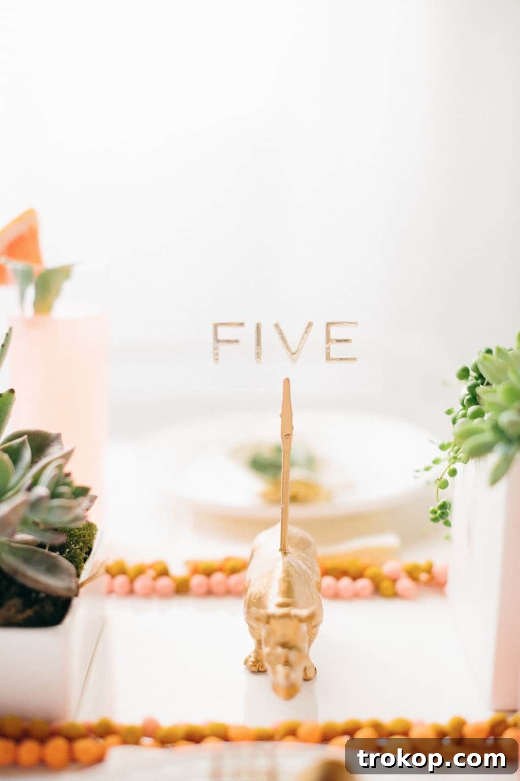 Detailed view of a DIY pom pom placemat with a delightful mix of white, gold, and colorful pom poms