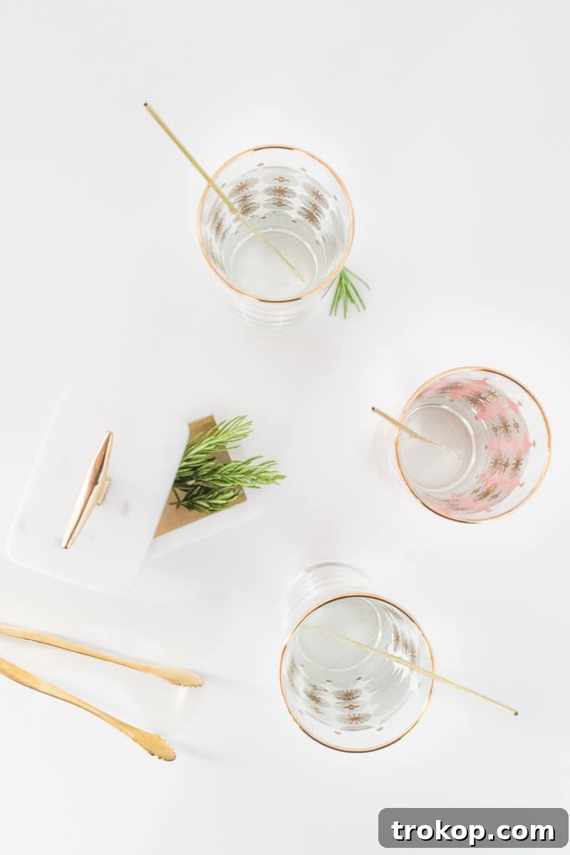 Array of finished DIY reusable gold drink stirrers in various cocktails on a stylish serving tray