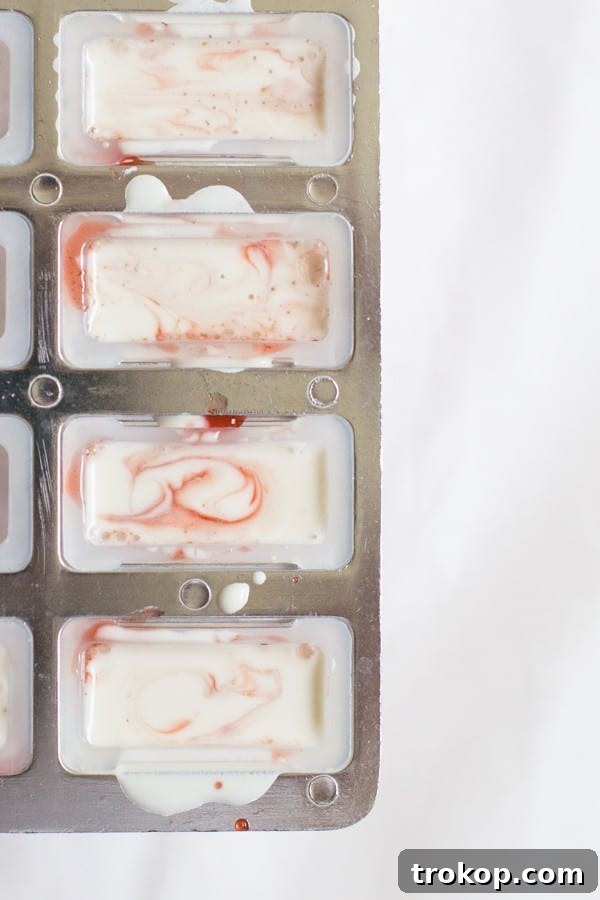Strawberry Coconut Swirl Pops 8 layering strawberry and coconut mixtures into popsicle molds