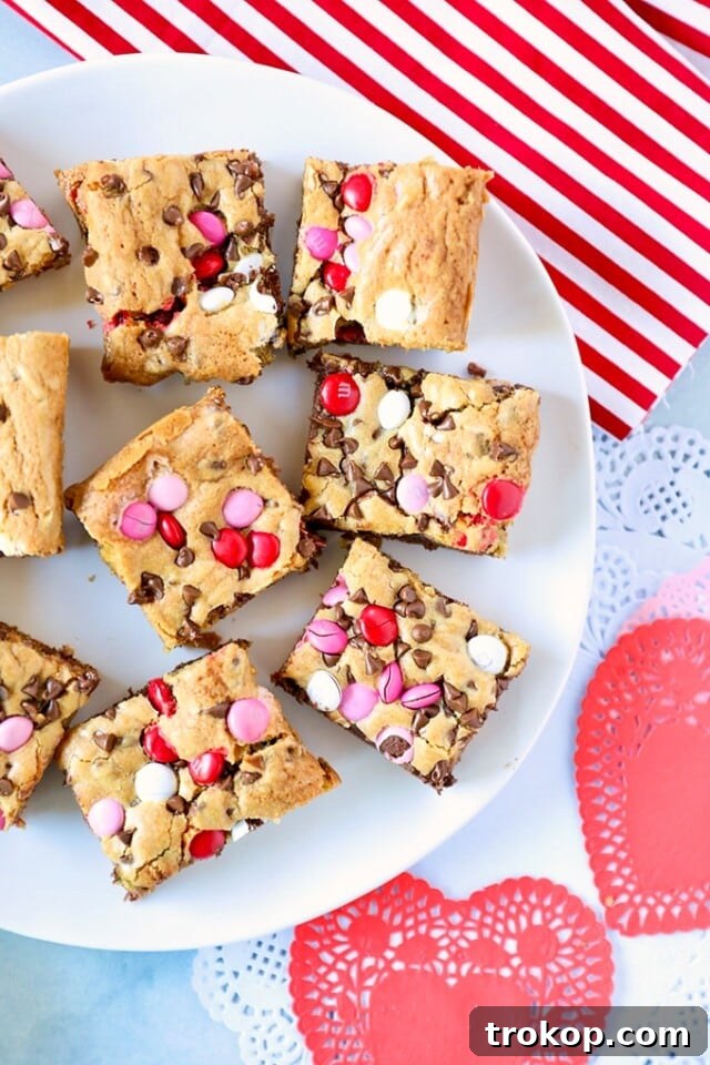 34 Irresistible Valentine's Day Treats 17 Festive Valentine’s Day cookie bars, generously loaded with chocolate chips and colorful red, white, and pink M&M’s for a vibrant, delicious treat.
