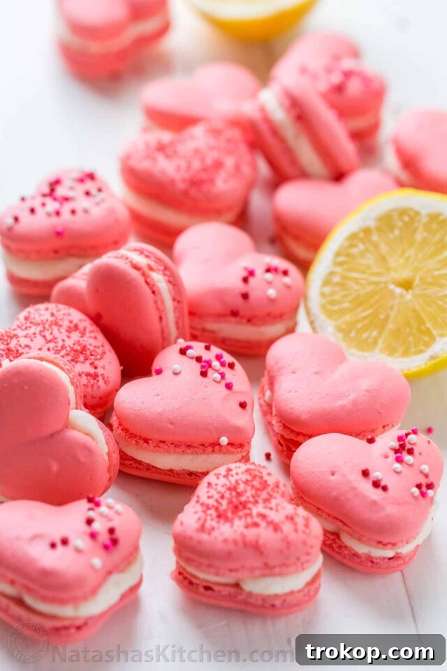 34 Irresistible Valentine's Day Treats 23 Delicate heart-shaped macarons with a vibrant pink hue, filled with zesty lemon buttercream, offering an elegant and charming Valentine's Day treat.