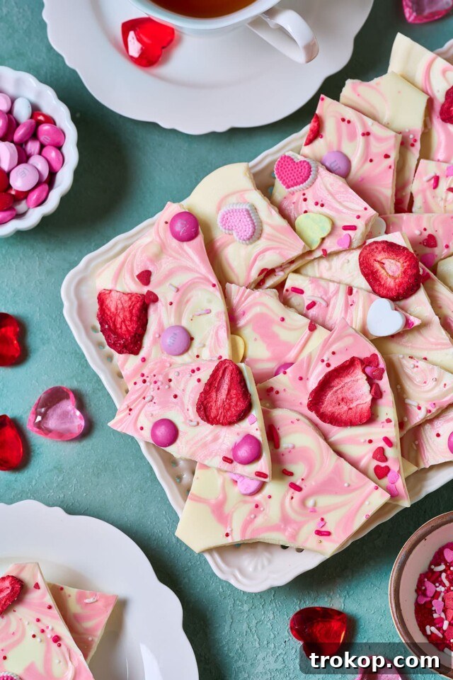 34 Irresistible Valentine's Day Treats 33 Creamy white chocolate bark with vibrant swirls of colorful vanilla candy melts, topped with festive candies, a sweet, fun, and customizable no-bake Valentine's Day dessert.