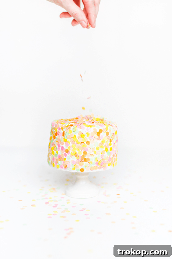 adding edible confetti toppings over a cake - edible confetti