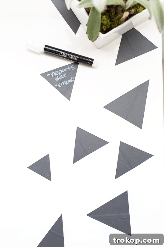Arranging multiple geometric chalkboard tape pieces on a desk