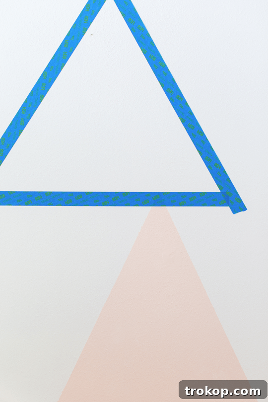 Step-by-step DIY geometric accent wall process: taping and painting