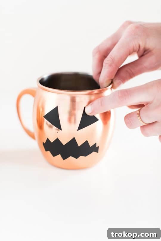 Spookify Your Glasses with Pumpkin Decals 5 Applying Halloween pumpkin decals to clean copper mugs