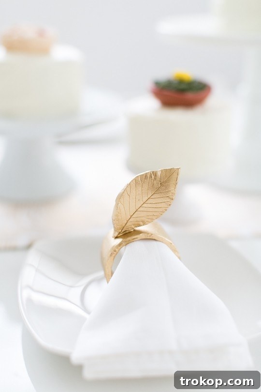 Materials laid out for crafting DIY gold leaf napkin rings, including air-dry clay and fresh leaves
