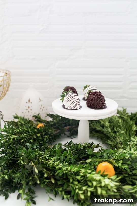 Dessert stand adorned with a festive wreath, featuring chocolate-covered strawberries.