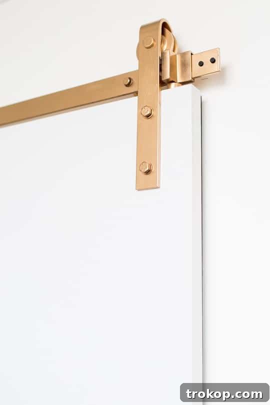 Materials and tools laid out for DIY barn door project including paint and hardware.