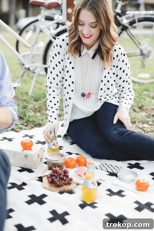 Daytime Adventures for Two 11 Couple enjoying their picnic, sharing a laugh over delicious food amidst a serene outdoor setting.