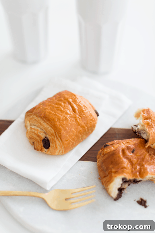 Two-Ingredient Chocolate Croissant Magic 4 A close-up of a two-ingredient chocolate croissant, showing its flaky layers and a peek of melted chocolate.