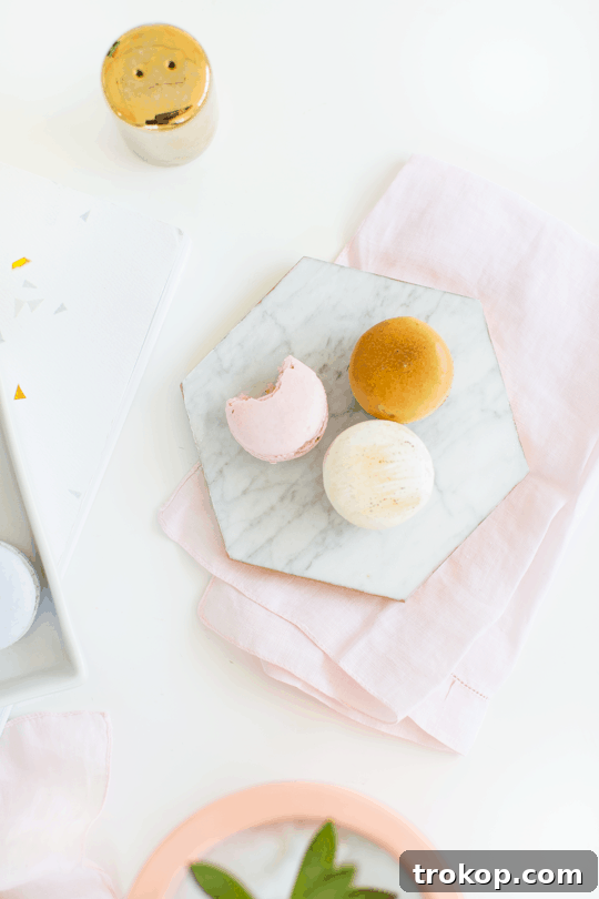 Close-up of DIY gilded marble hexagon serving boards featuring delicate macarons and cupcakes | sugar & cloth