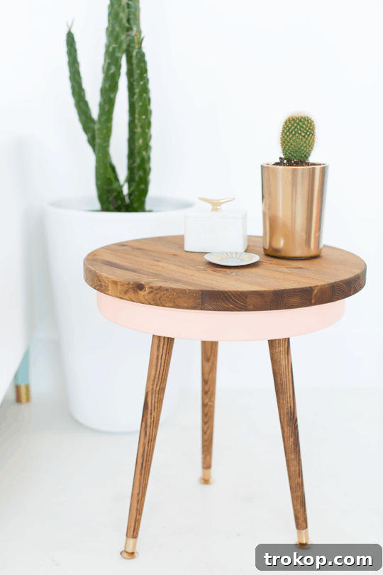 Close-up of a DIY Mid Century End Table with a colorful pink storage base and wooden top.