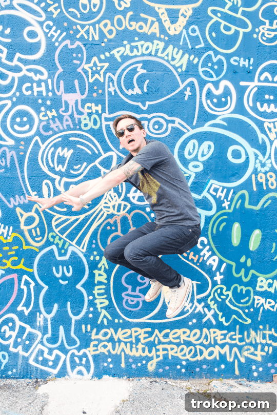 Miami's 24-Hour Adventure 16 Person jumping in front of a colorful Wynwood mural