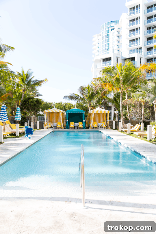 Miami's 24-Hour Adventure 8 Empty lounge chairs by the pool in a sunny resort