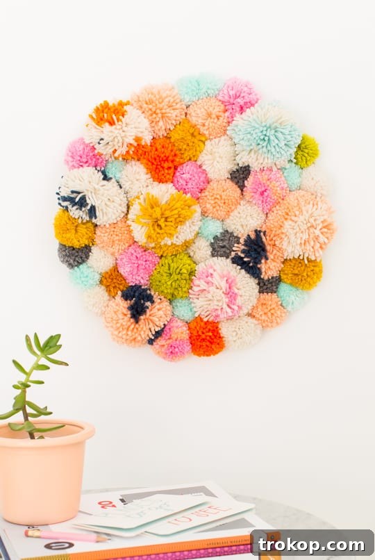 Handmade Pom Pom Wall Art 3 DIY Pom Pom Wall Hanging by Top Lifestyle Blogger Ashley Rose | Sugar & Cloth #DIY #pompom #wallhanging #yarn #yarnpompoms #homedecor #diydecor #colorful #make