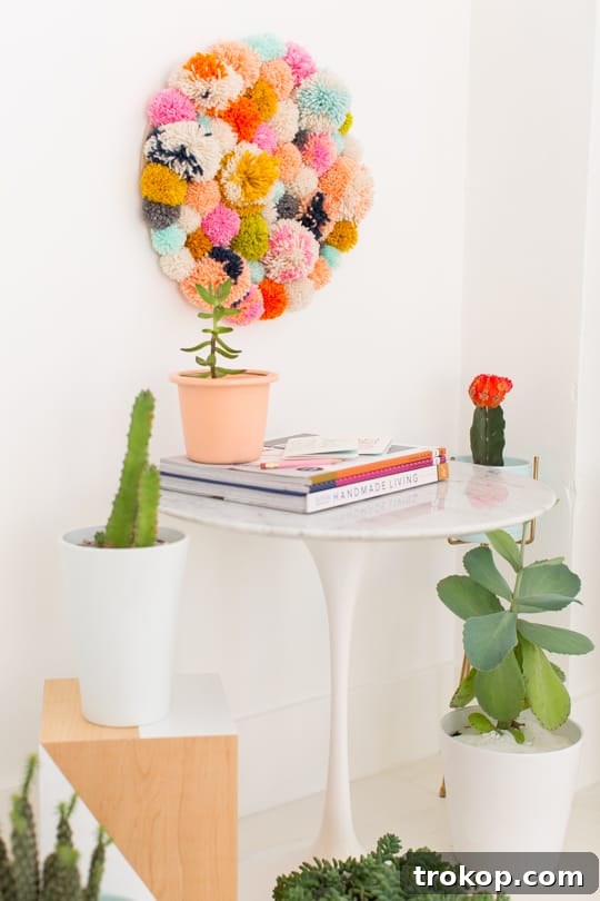 Handmade Pom Pom Wall Art 4 Step 5- DIY Pom Pom Wall Hanging by Top Lifestyle Blogger Ashley Rose | Sugar & Cloth #DIY #pompom #wallhanging #yarn #yarnpompoms #homedecor #diydecor #colorful #make