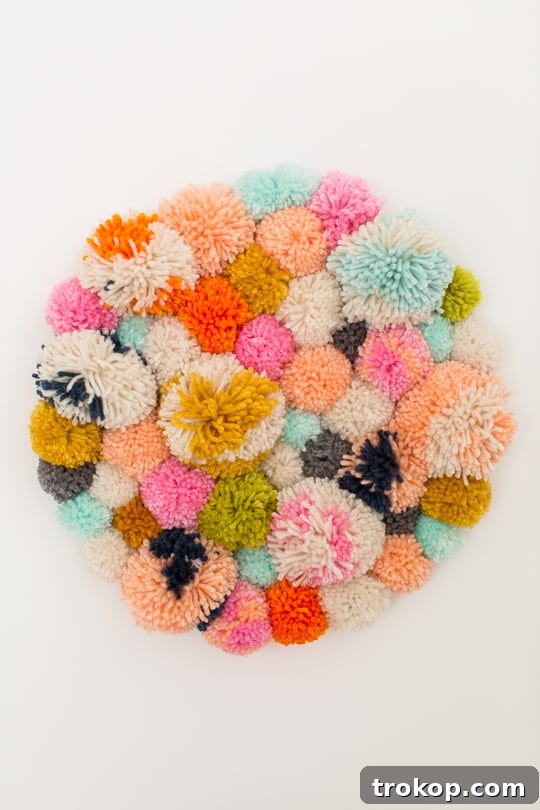 Handmade Pom Pom Wall Art 8 Step 4 - DIY Pom Pom Wall Hanging by Top Lifestyle Blogger Ashley Rose | Sugar & Cloth #DIY #pompom #wallhanging #yarn #yarnpompoms #homedecor #diydecor #colorful #make