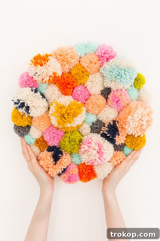 Handmade Pom Pom Wall Art 9 Step 7 -DIY Pom Pom Wall Hanging by Top Lifestyle Blogger Ashley Rose | Sugar & Cloth #DIY #pompom #wallhanging #yarn #yarnpompoms #homedecor #diydecor #colorful #make
