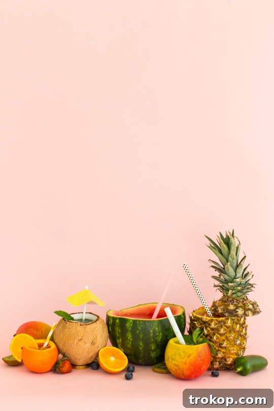 5 Refreshing Infused Water Recipes & DIY Fruit Cups 2 Freshly prepared fruit-infused water in a glass with colorful fruit slices