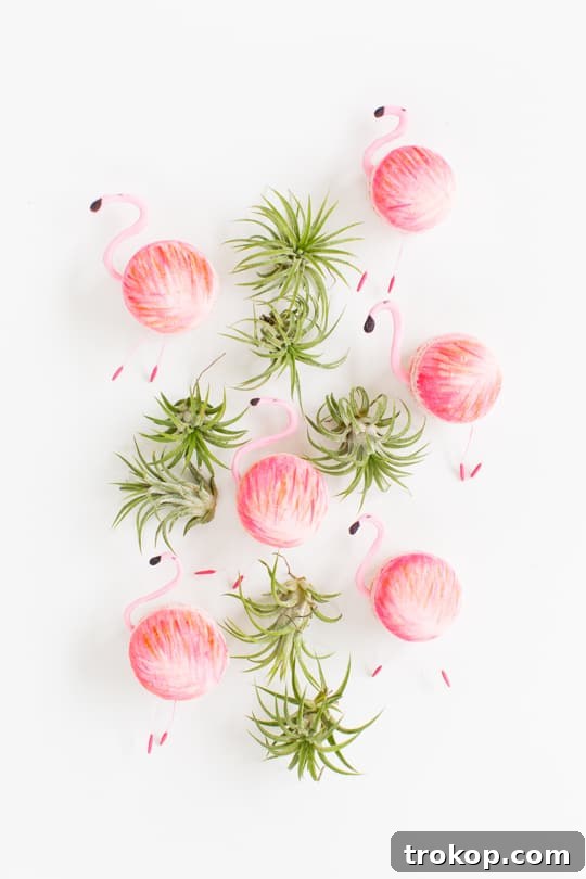 Delicate DIY flamingo macarons ready for decoration on a white surface