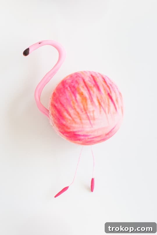 Assortment of flamingo macaron components: piped chocolate heads, painted shells, and stamens