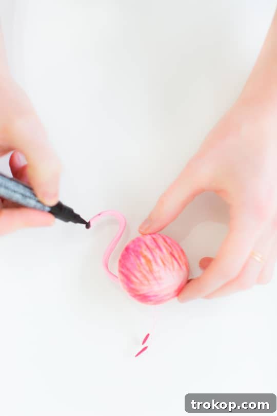 Food dedicated paintbrush applies delicate pink and peach strokes onto a strawberry macaron