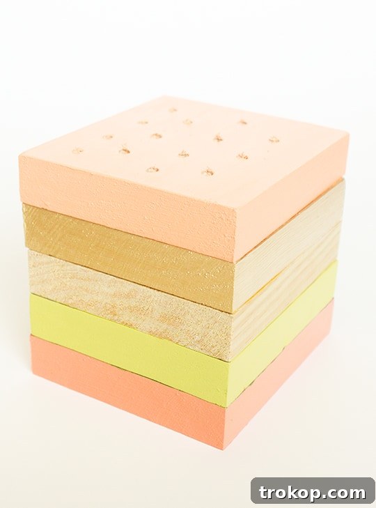 Applying wood glue to stack painted wooden boards for the cake