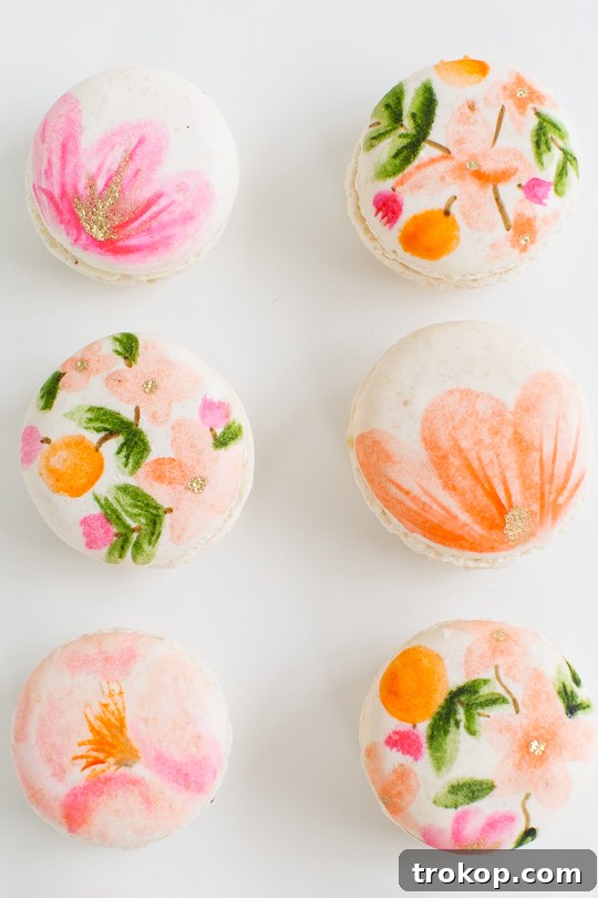 Blossom Bites: Crafting Hand-Painted Floral Macarons 13 Finished floral macarons with gold accents, presented beautifully.