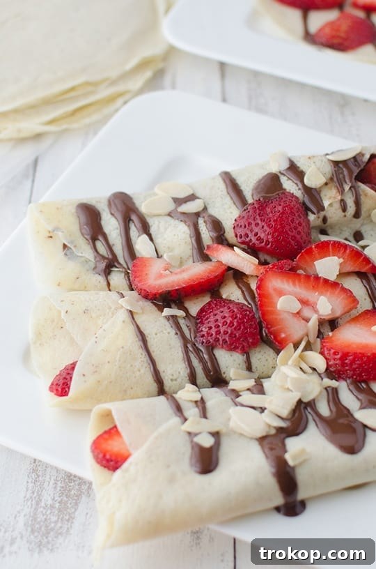 Strawberry Almond Crepes with Decadent Chocolate Drizzle 3 Close-up of strawberry almond crepes with chocolate sauce, highlighting the fresh ingredients