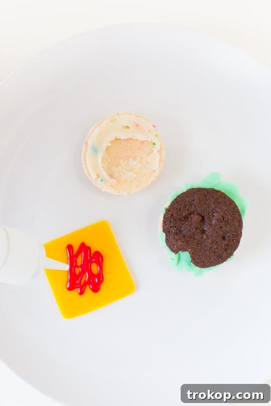 Mint green fondant being shaped and ruffled by hand to resemble miniature lettuce leaves for the macaron cheeseburgers.