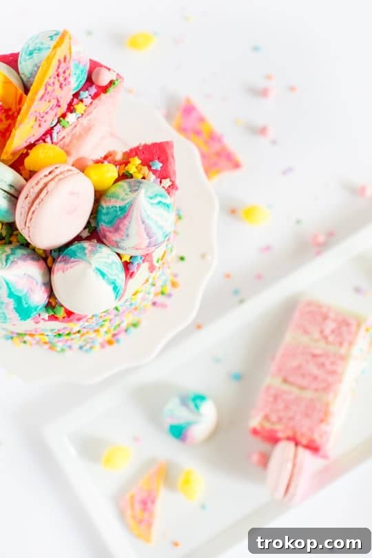 A close-up shot of the vibrant pink layers and creamy green coconut buttercream of the Unicorn Strawberry Cake, ready for decoration.