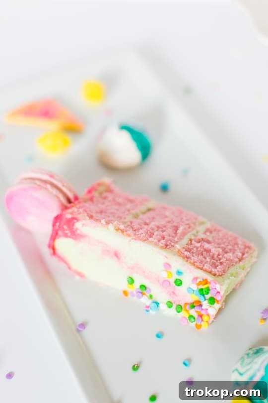 The fully assembled and frosted unicorn strawberry cake, adorned with colorful macarons and sprinkles.