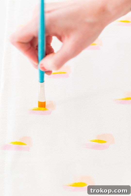 Close-up of fabric paint being applied with a brush in a consistent direction