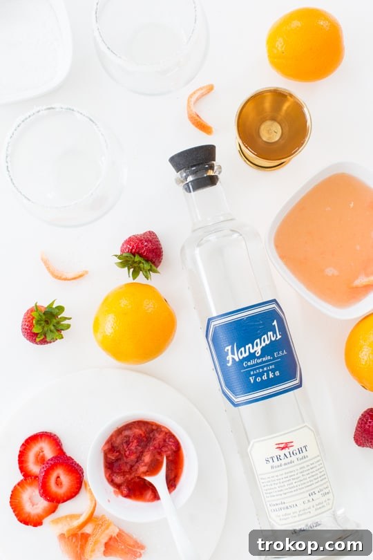 Ingredients for a Strawberry Grapefruit Salty Dog cocktail laid out on a table.