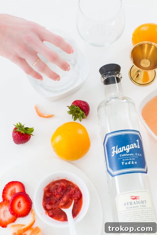 Hands preparing a grapefruit for squeezing juice, essential for the cocktail.