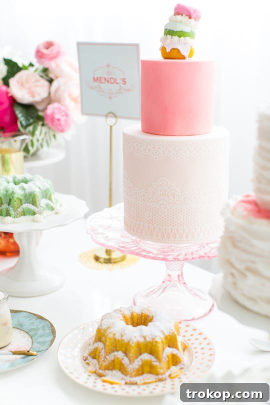 Collection of elegant pink cake stands with themed cakes for a tea party