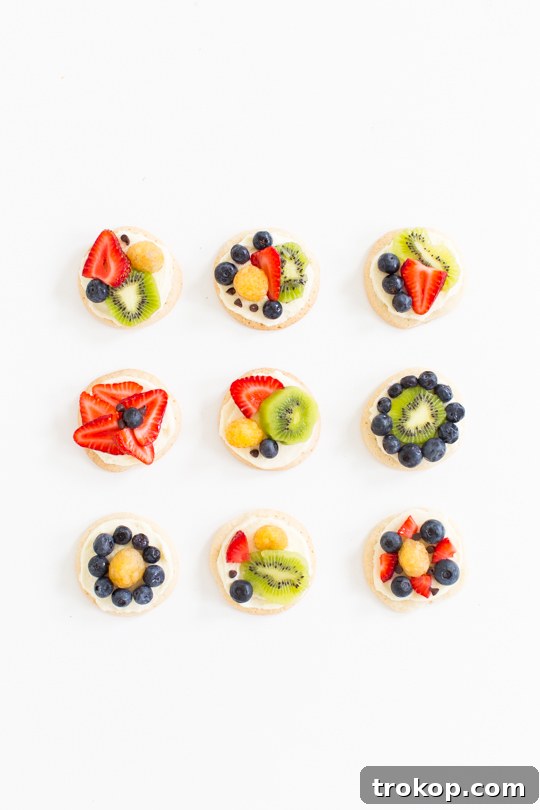 Arranging fresh berries and kiwi on a Mascarpone-frosted sugar cookie for a fruit pizza