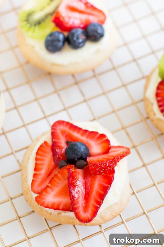 Variety of Fruit Pizza Cookies displayed on a wooden board